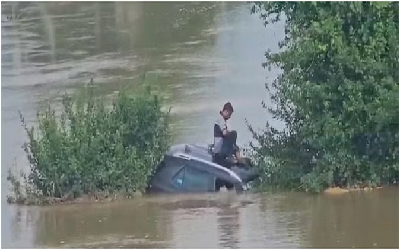 Flood News : बाढ़ ने मचाया हाहाकार : सड़कों और तालाबों में नहीं पता चल रहा अंतर, जान बचाने पेड़ पर चढ़ा कार सवार, दमकलकर्मियों ने बचाई जान